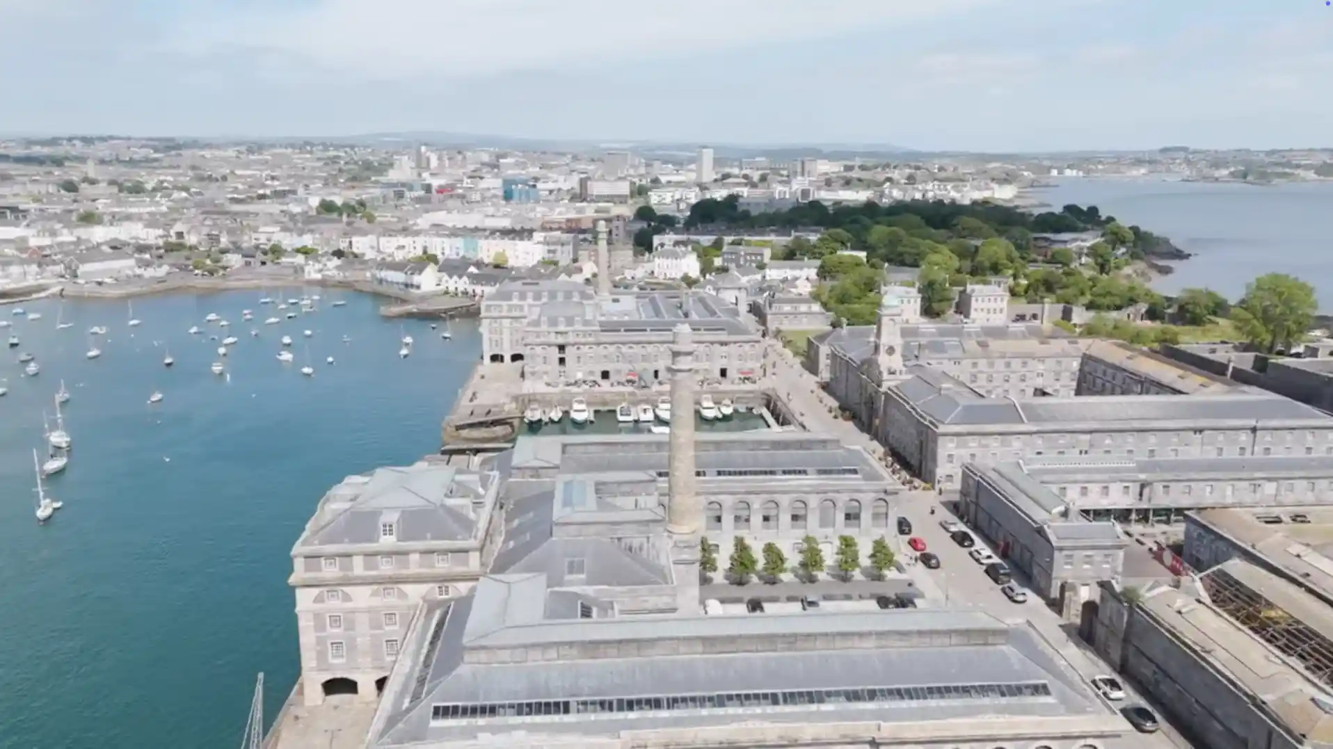 Aerial view of Royal William Yard’s central courtyard and marina in Plymouth, with Stonehouse Pool and the city in the background.
